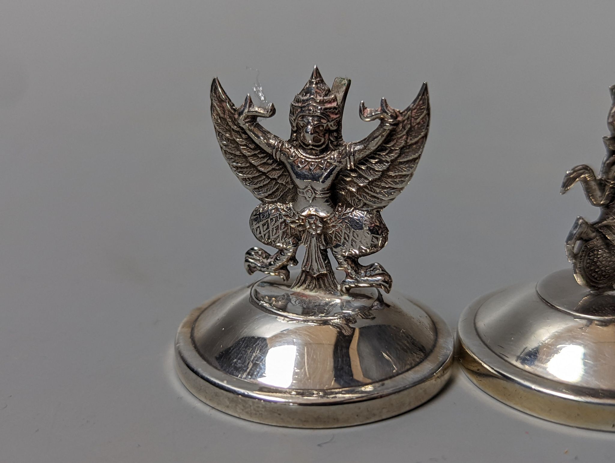 Sixteen assorted Siamese sterling mounted menu holders, modelled with figures, elephant, etc.